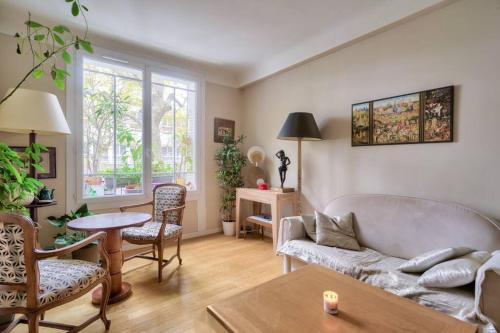 un salon avec un canapé et une table dans l'établissement Appart calme à Buttes-Chaumont, à Paris