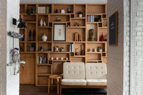 a living room with a chair and a book shelf at Simply Sleep Hostel in Bangkok