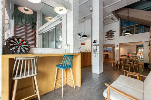 a bar in a restaurant with two blue bar stools at Simply Sleep Hostel in Bangkok