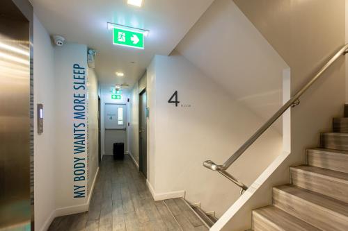 a stairwell in a hospital with a sign on the wall at Simply Sleep Hostel in Bangkok