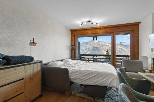a bedroom with a bed and a view of a mountain at Charmant studio à côté des pistes de ski in Nendaz