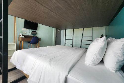 a bedroom with a large bed with white pillows at Simply Sleep Hostel in Bangkok