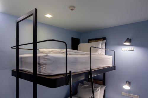 a bedroom with two bunk beds in a blue room at Simply Sleep Hostel in Bangkok