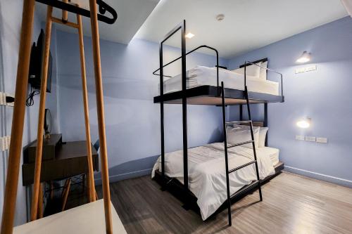 a room with two bunk beds and a desk at Simply Sleep Hostel in Bangkok