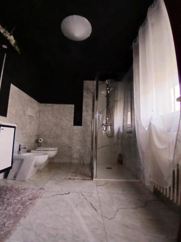 a bathroom with two toilets and a sink and a shower at Sweet House in Solesino