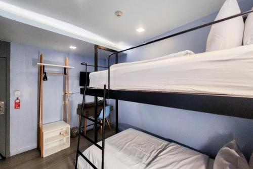 two bunk beds in a room with blue walls at Simply Sleep Hostel in Bangkok