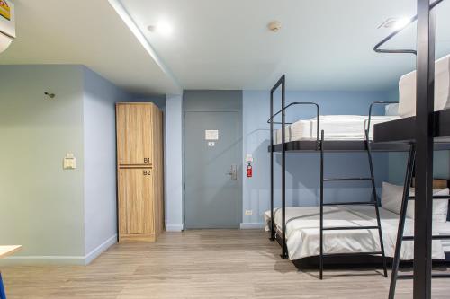 a room with two bunk beds and a hallway at Simply Sleep Hostel in Bangkok
