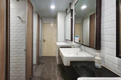 a bathroom with two sinks and a large mirror at Simply Sleep Hostel in Bangkok