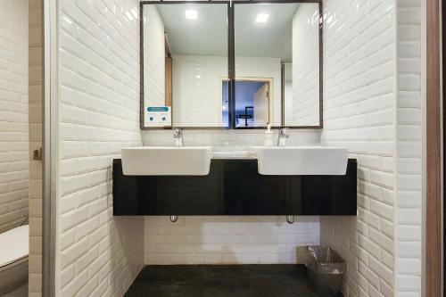 a bathroom with two sinks and a mirror at Simply Sleep Hostel in Bangkok