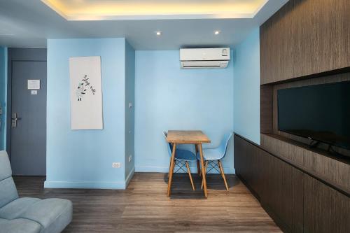 a room with a table and a tv and a stool at Simply Sleep Hostel in Bangkok