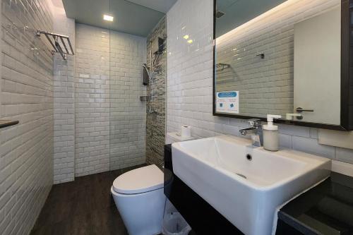 a white bathroom with a sink and a toilet at Simply Sleep Hostel in Bangkok