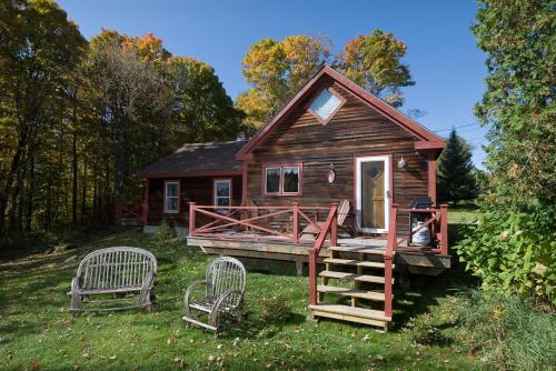 a small cabin with two chairs in front of it at Goldilocks Cabin in Stowe