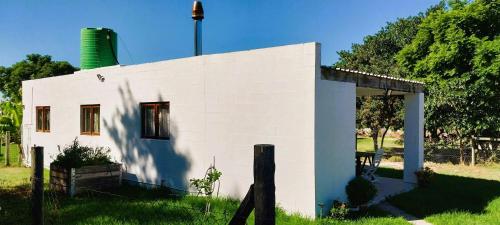 una pequeña casa blanca con un patio de césped en Little Farmstay, en Malmesbury
