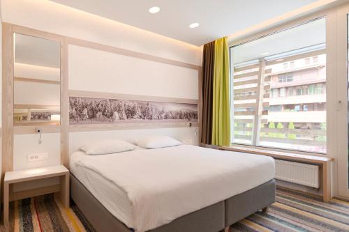 a bedroom with a bed and a large window at Hotel Han Bjelašnica in Bjelašnica