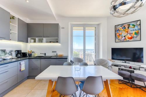 - une cuisine avec une table et des chaises blanches dans l'établissement LE SINATRA splendide vue mer panoramique et balcon, idéal pour des séjours de loisirs ou business, à Cannes