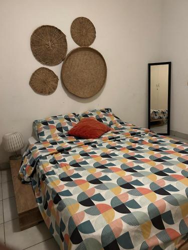 a bedroom with a bed with a colorful comforter at Le Nid Douillet de Cécilia in Libreville