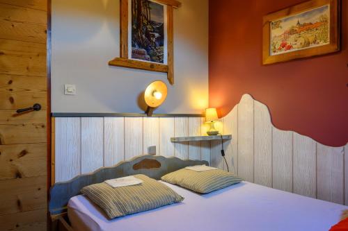 une chambre avec un lit avec deux oreillers dessus dans l'établissement Chalet Myrtilles, à Saint-Maurice-sur-Moselle