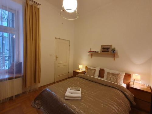 a bedroom with a bed with two lamps and a window at B-4 Kraków Stary Kazimierz O&P ApartFamily in Kraków