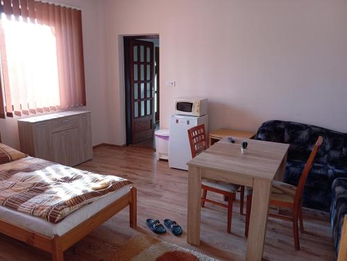a living room with a table and a couch at Vendégváró szálláshely Sajószentpéteren in Sajószentpéter