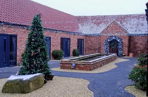 a christmas tree in front of a brick building at Sherwood Lodge in Wellow