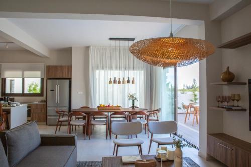 a kitchen and dining room with a table and chairs at LIV & CO Suites & Villas in Voroklini
