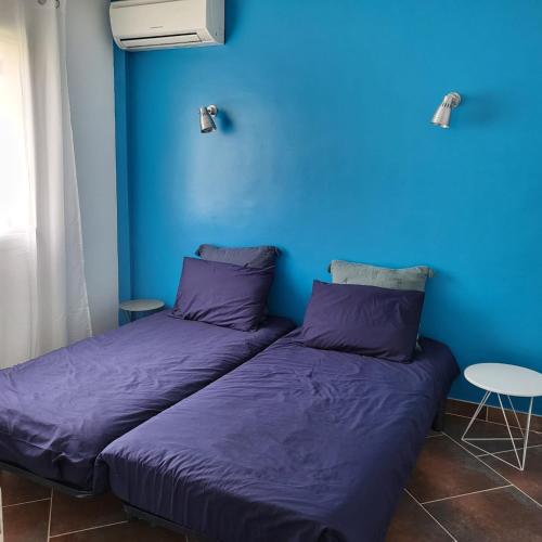 - 2 lits dans une chambre avec un mur bleu dans l'établissement Maison 6 personnes 3 chambres Aéroport-Plages, à Marignane