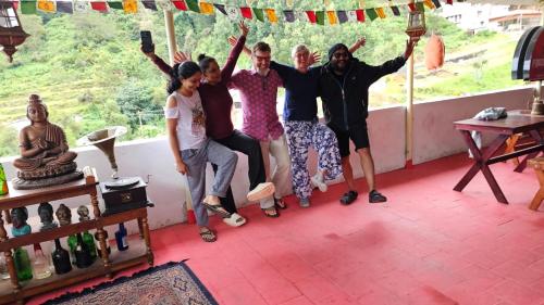 a group of people posing for a picture in a room at Frozen Monks in Kodaikānāl