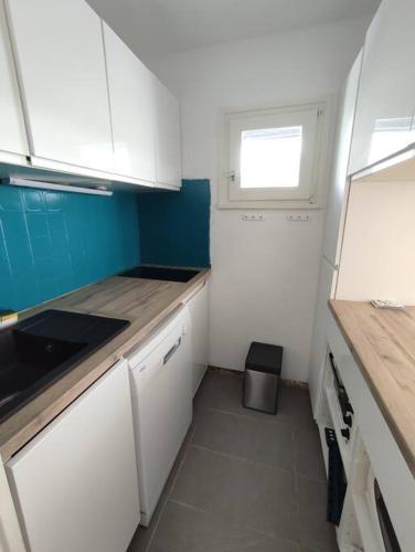 Elle comprend une petite cuisine avec des placards blancs et une fenêtre. dans l'établissement BOR54 - Joli T3 lumineux 6pers, skis au pieds, à Tignes