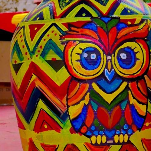 a colorful owl with glasses sitting on a colorful vase at Frozen Monks in Kodaikānāl