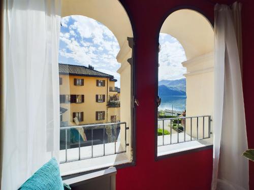 a room with a red door and two windows with a view at Antica torre del castello Casa Ceresiana in Carabietta