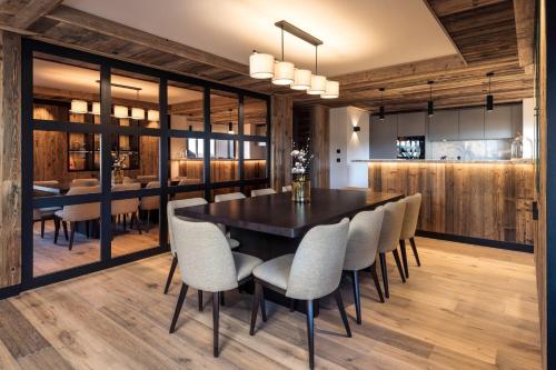 a dining room with a black table and chairs at Antarès SIRIUS 302 - Ski inski out family apartment in Méribel