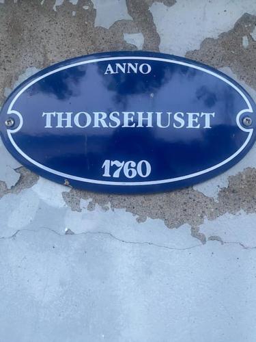a blue sign that reads amno horsethurst at Villa Thorse in Husvik
