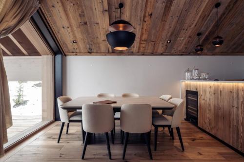 une salle à manger avec un plafond en bois, une table et des chaises dans l'établissement Antarès SIRIUS 301- Spacious ski inski out apartment, à Méribel