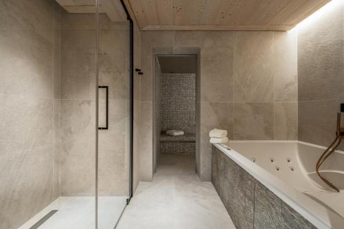 a bathroom with a shower and a bath tub at Antarès SIRIUS 503 - Spacious ski inski out apartment in Méribel