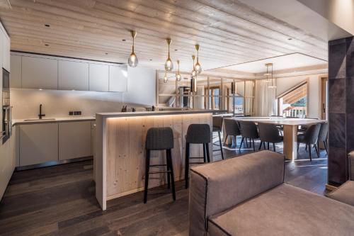 - une cuisine avec un bar avec des chaises et une table dans l'établissement Antarès SIRIUS 503 - Spacious ski inski out apartment, à Méribel