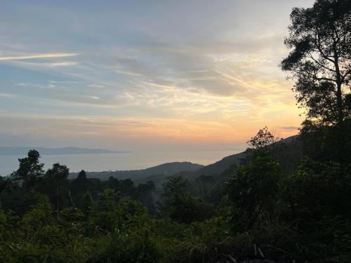 a view of a valley with trees and a sunset at The Hidden Gem Viewpoint Camping & Rooms in Ban Nok