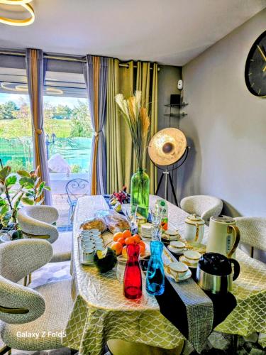 - une table à manger avec de la nourriture et des chaises dans l'établissement Maison Romantique entre deux fleuves chez l'habitant, à Montereau-faut-Yonne