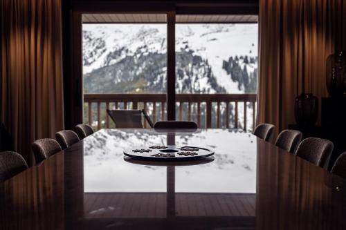 - une table dans une chambre avec vue sur une montagne enneigée dans l'établissement Antarès SIRIUS 304 - Spacious ski inski out family apartment, à Méribel