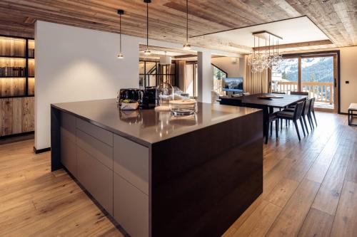 une cuisine ouverte et une salle à manger avec une grande île dans l'établissement Antarès SIRIUS 502 - Spacious rooftop ski inski out apartment, à Méribel