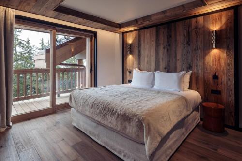 a bedroom with a large bed and a large window at Antarès URSA 402 - luxury apartment ski inski out in Méribel