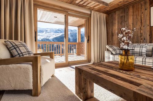 un salon avec une table et une grande fenêtre dans l'établissement Antarès SIRIUS 303 - Spacious ski inski out apartment, à Méribel