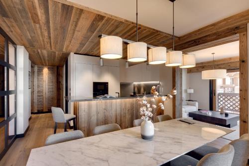 une cuisine et une salle à manger avec une table et des chaises dans l'établissement Antarès NAOS 102 - luxury apartment ski inski out, à Méribel