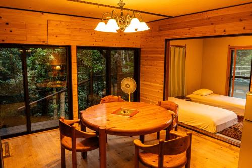 una sala da pranzo con tavolo e letto e una camera da letto di 貸別荘吉佐美苑 a Shimoda