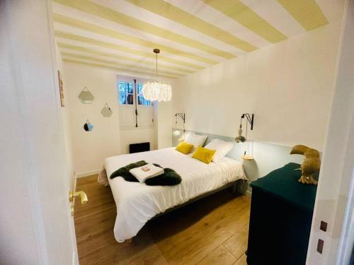 une chambre avec un lit avec des draps blancs et des oreillers jaunes dans l'établissement Chez Madeleine au Petit Palais, à Périgueux