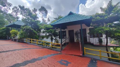 a small building with a yellow fence next to it at HOTEL MEENAKSHI in Kolattupuzha