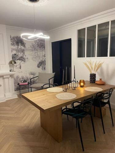 une salle à manger avec une table et des chaises en bois dans l'établissement Appartement de standing à 2 pas de la gare, à Saint-Brieuc