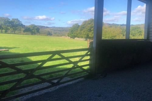 a window with a fence looking out at a field at The Milking Parlour at Berthllwyd in Quakers Yard