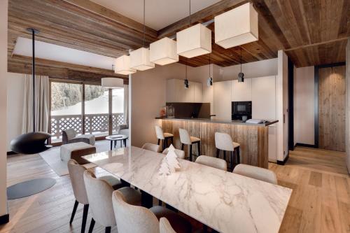 Il comprend une cuisine et une salle à manger avec une table et des chaises en marbre. dans l'établissement Antarès NAOS 201 - luxury apartment ski inski out, à Méribel