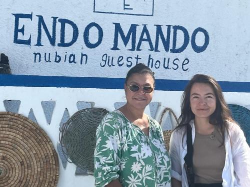 two women are standing in front of a sign at Endo Mando in Shellal