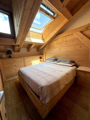 una camera con un grande letto in un soffitto in legno di Attico Bellavista a Cortina dʼAmpezzo